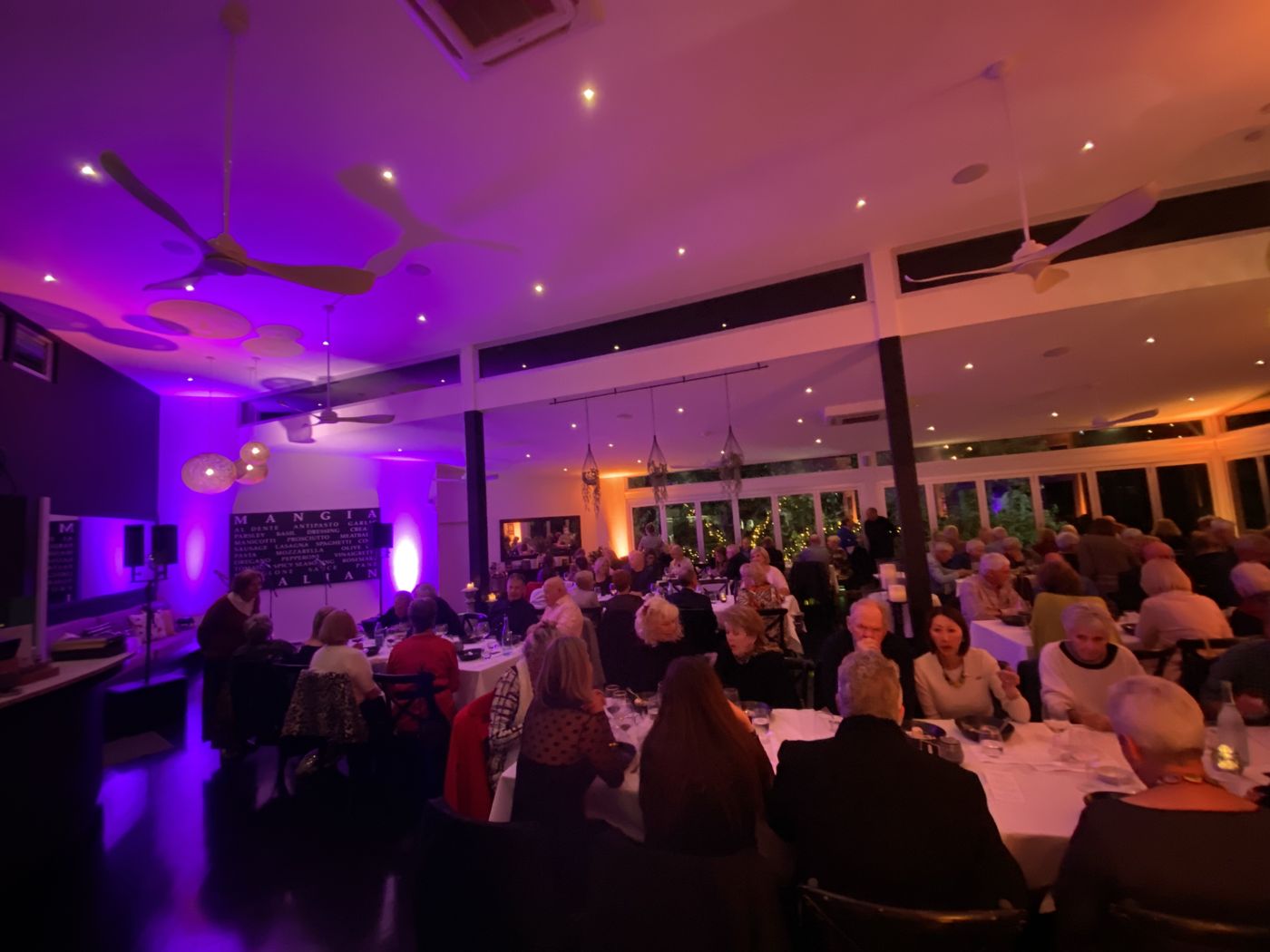 Dinner function with purple uplighting around the room